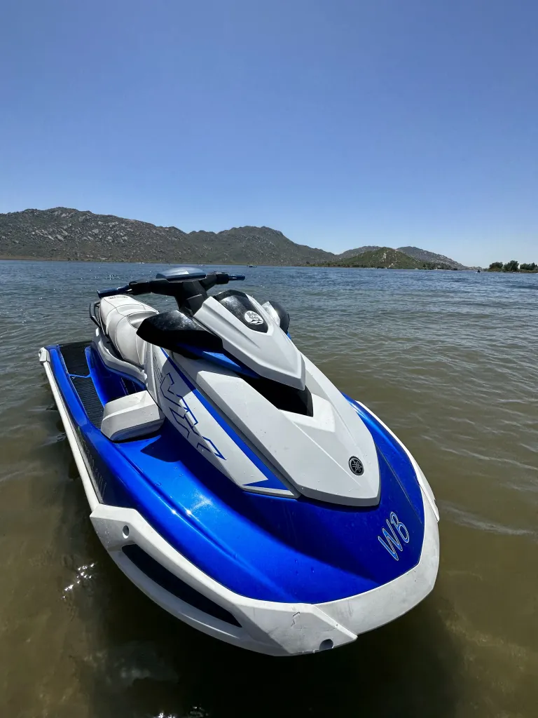 Multiple Waterboiis jet skis lined up on the lake near shore.